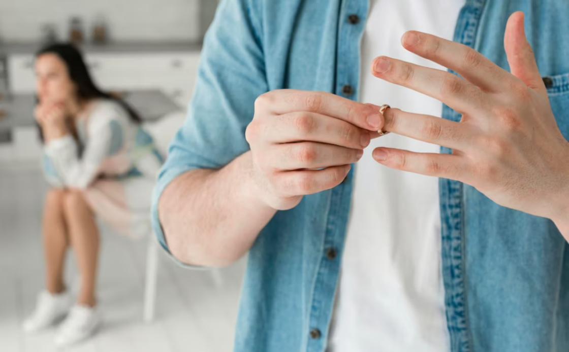 Мужчина снимает обручальное кольцо Мужчина снимает обручальное кольцо