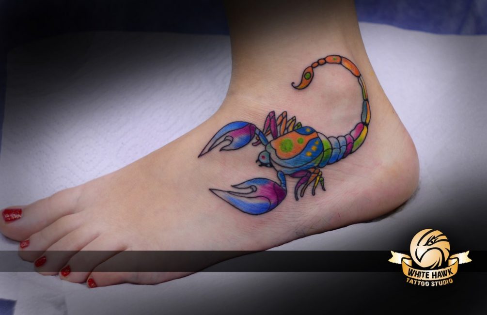 Цветной скорпион на ноге женщины Цветной скорпион на ноге женщины